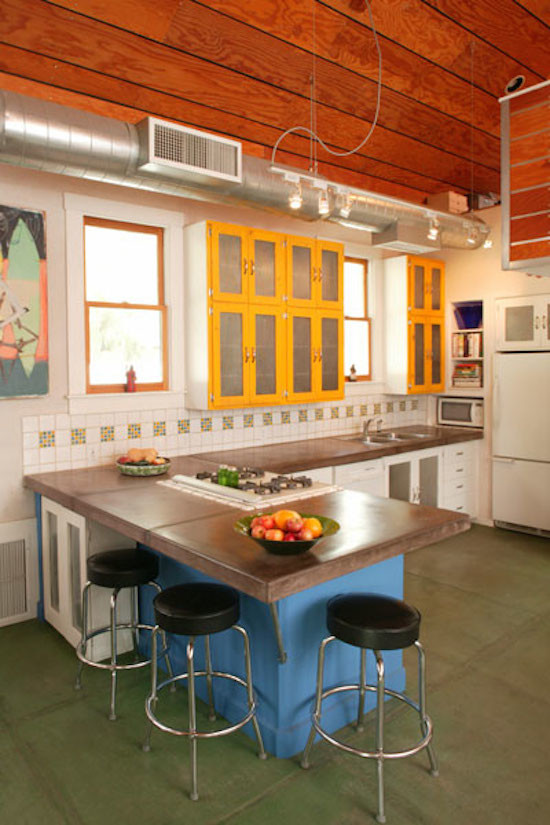 Eklektisk inredning av ett linjärt kök med öppen planlösning, med en dubbel diskho, luckor med glaspanel, gula skåp, vitt stänkskydd, stänkskydd i keramik och vita vitvaror