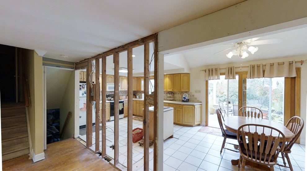 Foto di una grande cucina tradizionale con lavello sottopiano, ante con bugna sagomata, ante beige, top in granito, paraspruzzi beige, paraspruzzi con piastrelle in pietra, elettrodomestici in acciaio inossidabile, pavimento in legno massello medio e pavimento marrone