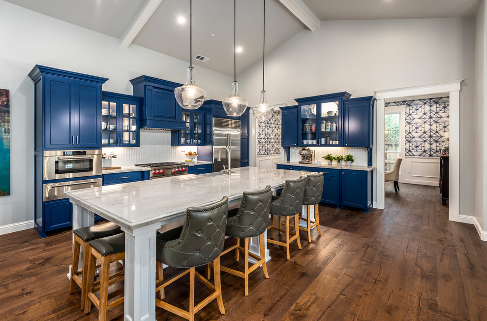 Photo of a traditional l-shaped kitchen in Sacramento with a belfast sink, shaker cabinets, blue cabinets, white splashback, stainless steel appliances, dark hardwood flooring and an island.