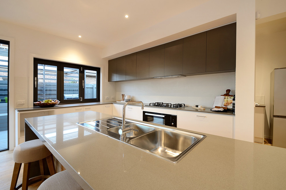 Große Moderne Wohnküche in L-Form mit Doppelwaschbecken, Quarzwerkstein-Arbeitsplatte, Küchenrückwand in Weiß, Rückwand aus Zementfliesen, Küchengeräten aus Edelstahl, braunem Holzboden und Kücheninsel in Melbourne