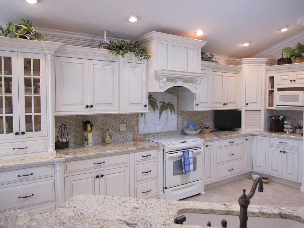 Exotisk inredning av ett mellanstort kök och matrum, med vita skåp, granitbänkskiva, flerfärgad stänkskydd och vita vitvaror