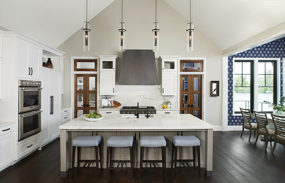 Eat-in kitchen - transitional l-shaped dark wood floor, brown floor and vaulted ceiling eat-in kitchen idea in Grand Rapids with an undermount sink, shaker cabinets, white backsplash, an island, white countertops, white cabinets, paneled appliances, quartz countertops and quartz backsplash