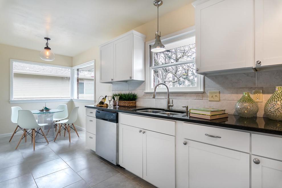 Large midcentury l-shaped open plan kitchen in Boise with a double-bowl sink, shaker cabinets, white cabinets, granite worktops, white splashback, ceramic splashback, stainless steel appliances, porcelain flooring and no island.
