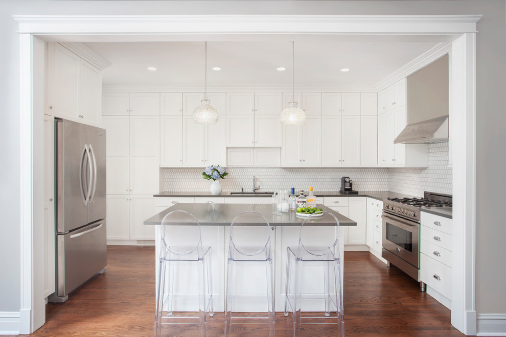 Enclosed kitchen - large transitional l-shaped medium tone wood floor and beige floor enclosed kitchen idea in Chicago with an undermount sink, shaker cabinets, white cabinets, quartz countertops, white backsplash, ceramic backsplash, stainless steel appliances and an island