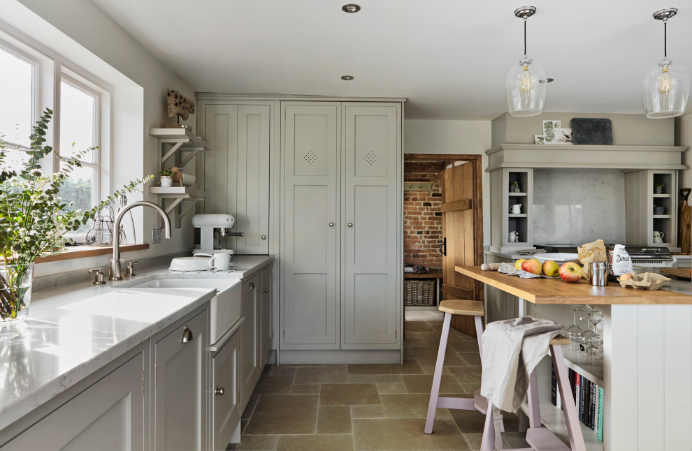 Inspiration for a large farmhouse open concept kitchen remodel in London with a farmhouse sink, shaker cabinets, quartzite countertops and an island
