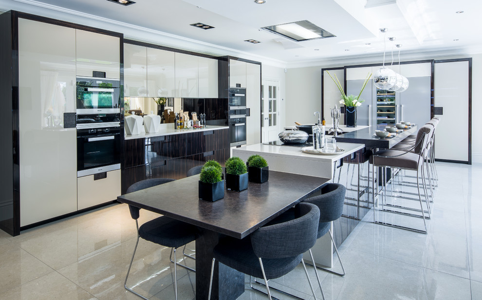 Expansive contemporary open plan kitchen in Berkshire with a submerged sink, flat-panel cabinets, granite worktops, mirror splashback, porcelain flooring and multiple islands.