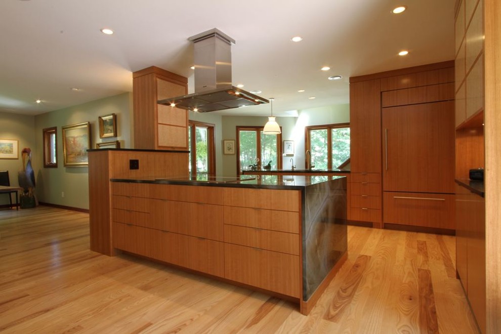 Inspiration pour une cuisine américaine encastrable design en bois brun avec un placard à porte plane et un plan de travail en granite.