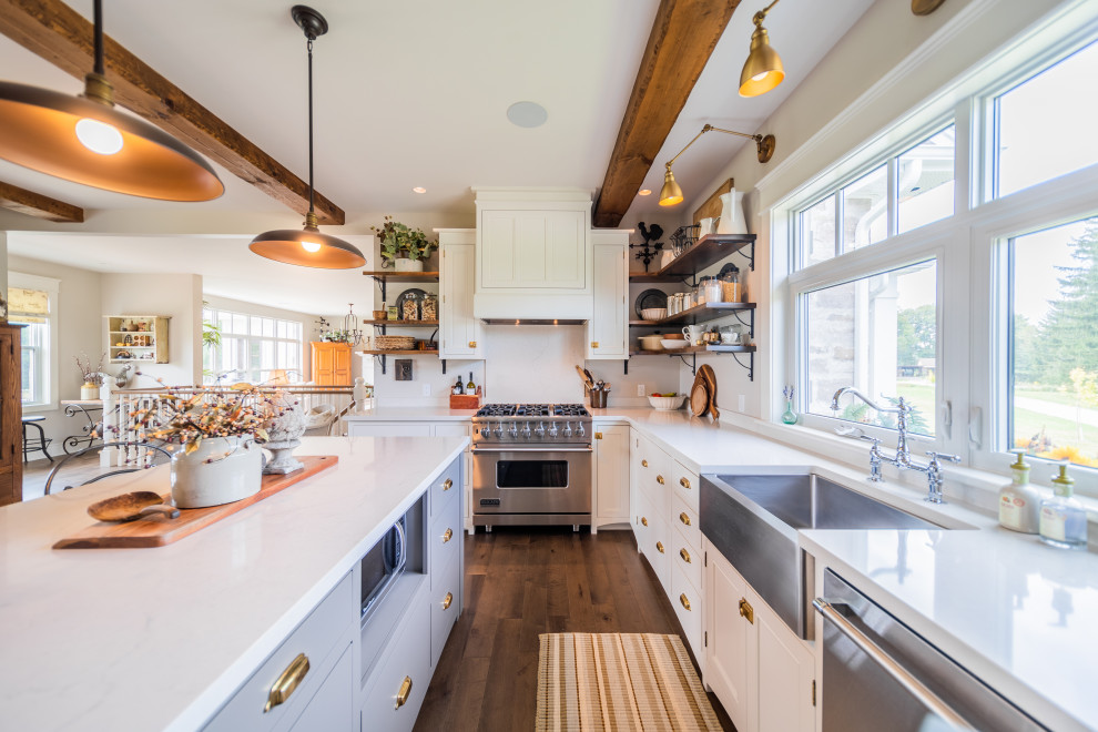 Inspiration for a large timeless l-shaped medium tone wood floor and brown floor eat-in kitchen remodel with a farmhouse sink, white cabinets, quartz countertops, stainless steel appliances, an island, shaker cabinets, white backsplash and beige countertops