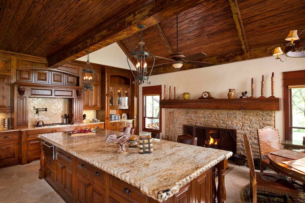 Modelo de cocina comedor rústica con armarios con paneles con relieve, puertas de armario de madera oscura, salpicadero beige y chimenea