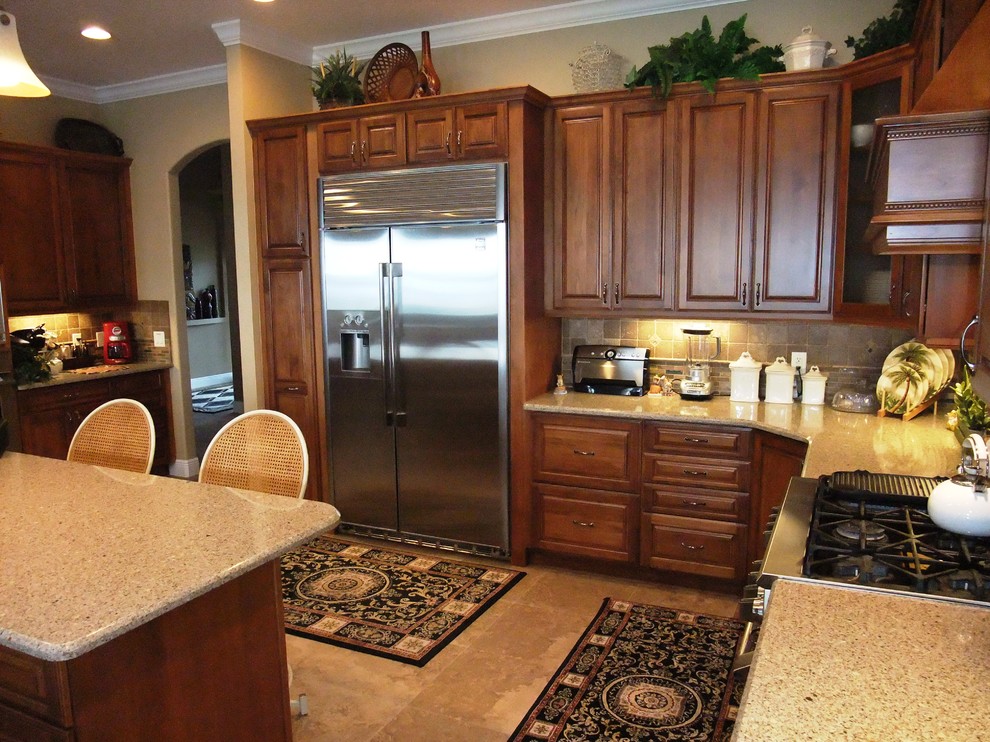 Exempel på ett stort klassiskt kök, med luckor med upphöjd panel, skåp i mellenmörkt trä, bänkskiva i kvarts, rostfria vitvaror och en köksö