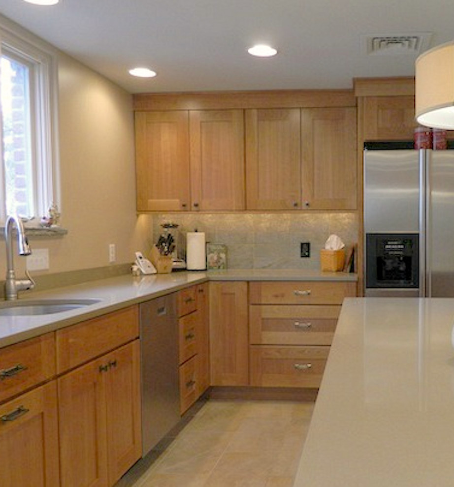 This is an example of a large modern l-shaped kitchen/diner in Philadelphia with a submerged sink, recessed-panel cabinets, medium wood cabinets, granite worktops, beige splashback, stone slab splashback, stainless steel appliances, ceramic flooring and an island.