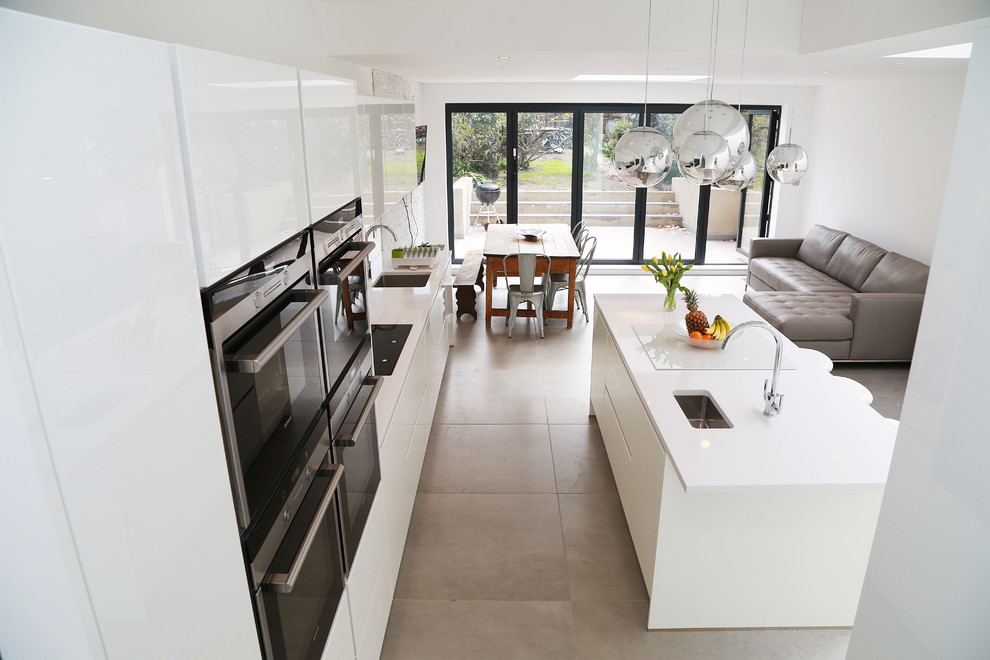 Große Moderne Küche mit Glasfronten, weißen Schränken, Küchengeräten aus Edelstahl und Kücheninsel in London