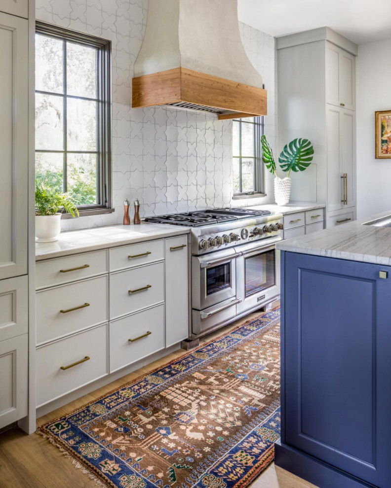 Tuscan medium tone wood floor kitchen photo in San Francisco with white cabinets, marble countertops, white backsplash, ceramic backsplash and an island
