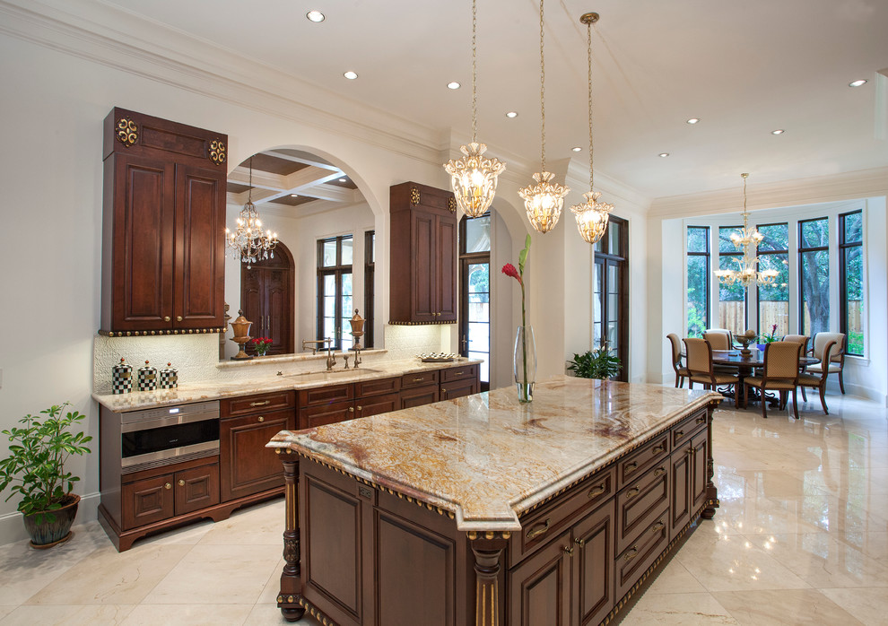Inspiration for a large timeless u-shaped eat-in kitchen remodel in Houston with an undermount sink, raised-panel cabinets, granite countertops, beige backsplash, ceramic backsplash, stainless steel appliances and an island
