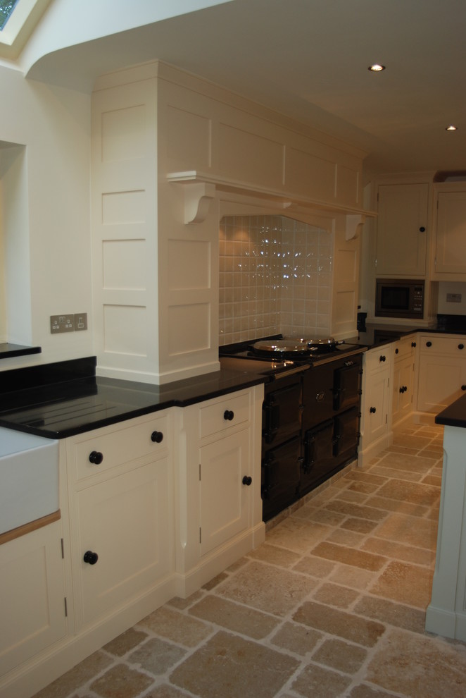 Design ideas for a large traditional u-shaped open plan kitchen in Sussex with beaded cabinets, granite worktops, beige splashback, an island and black worktops.