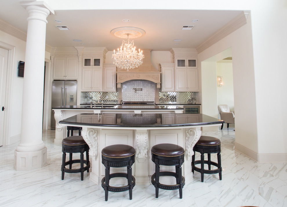 Example of a huge ornate single-wall ceramic tile open concept kitchen design in New Orleans with a double-bowl sink, white cabinets, granite countertops, metallic backsplash, glass tile backsplash, stainless steel appliances and two islands