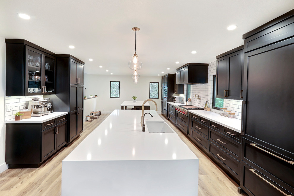 Example of a huge transitional galley eat-in kitchen design in San Francisco with shaker cabinets, black cabinets, quartz countertops, white backsplash, subway tile backsplash, stainless steel appliances, two islands and white countertops