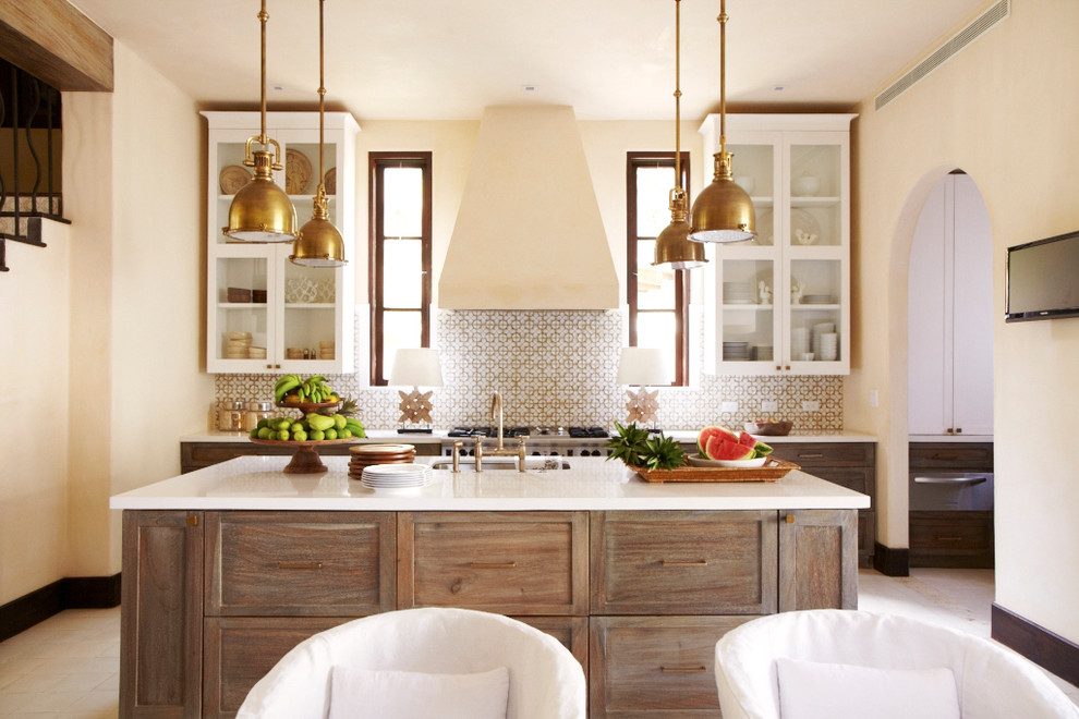 Mediterrane Wohnküche mit Unterbauwaschbecken, Glasfronten, weißen Schränken, bunter Rückwand, Küchengeräten aus Edelstahl und Kücheninsel in Sonstige