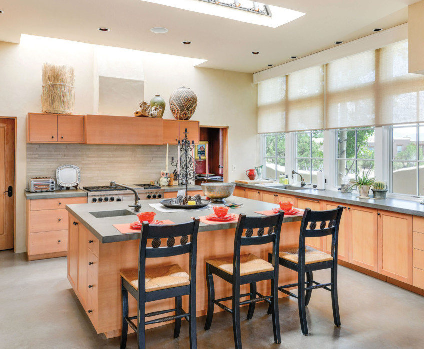 Mid-sized arts and crafts l-shaped concrete floor and gray floor eat-in kitchen photo in Albuquerque with an undermount sink, shaker cabinets, medium tone wood cabinets, concrete countertops, beige backsplash, stone tile backsplash, stainless steel appliances and an island