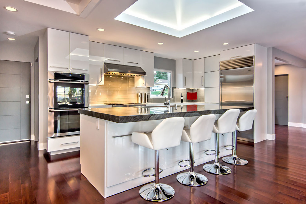 Moderne Küche mit flächenbündigen Schrankfronten, weißen Schränken, Küchengeräten aus Edelstahl, braunem Holzboden und Kücheninsel in San Francisco