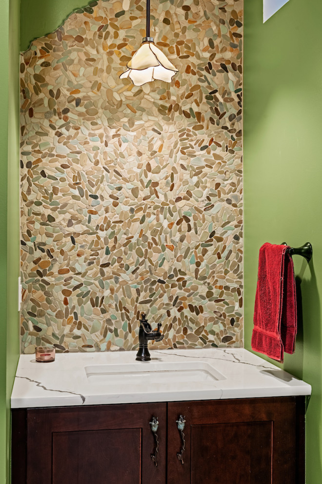 Powder room - mid-sized eclectic beige tile, brown tile, gray tile and pebble tile medium tone wood floor and brown floor powder room idea in Other with recessed-panel cabinets, dark wood cabinets, green walls, an undermount sink, marble countertops, white countertops and a built-in vanity