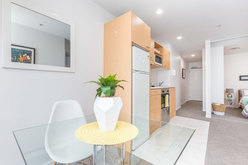 Kleine Moderne Wohnküche mit Teppichboden und grauem Boden in Auckland