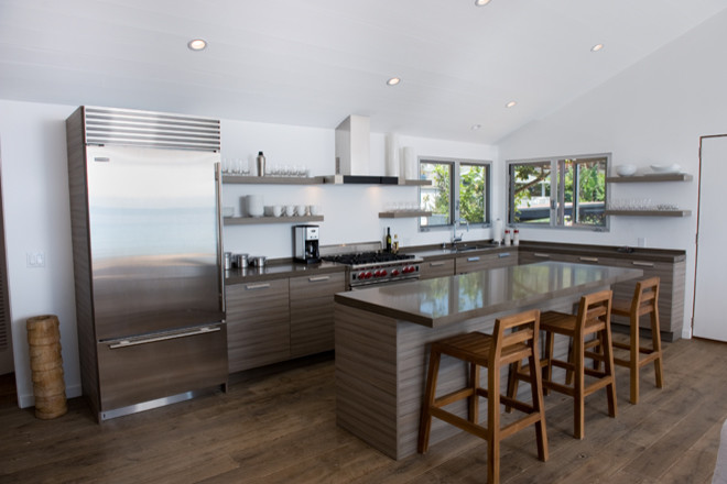 Bild på ett mellanstort funkis kök, med en undermonterad diskho, släta luckor, grå skåp, granitbänkskiva, rostfria vitvaror, mörkt trägolv, en köksö och brunt golv