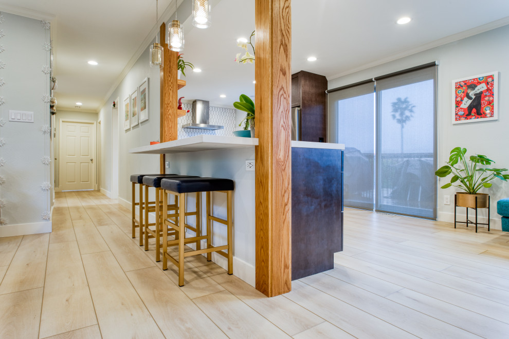Immagine di una cucina ad U moderna di medie dimensioni con paraspruzzi bianco, elettrodomestici in acciaio inossidabile, pavimento in vinile, penisola, pavimento giallo e top bianco