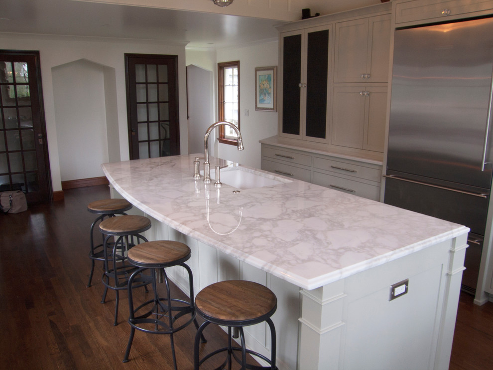 Elegant u-shaped kitchen photo in Portland with an undermount sink, white cabinets and marble countertops