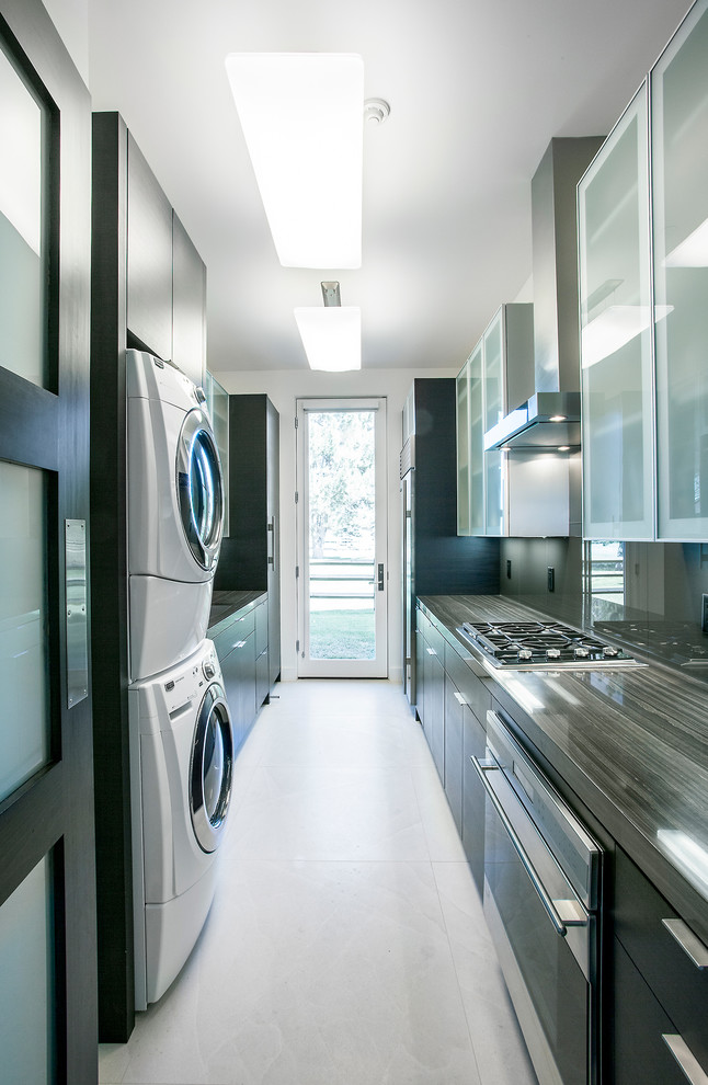 На фото: параллельная, отдельная кухня со стиральной машиной в современном стиле с фартуком из стекла, черными фасадами и плоскими фасадами