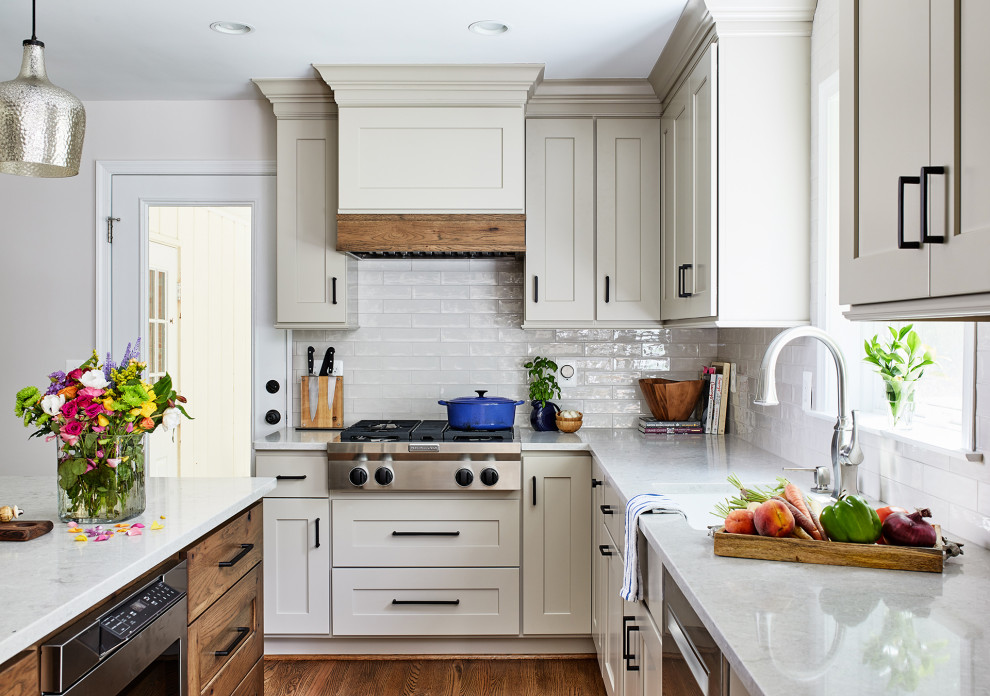 Idéer för ett mellanstort klassiskt vit kök, med en undermonterad diskho, luckor med infälld panel, beige skåp, bänkskiva i kvarts, vitt stänkskydd, stänkskydd i keramik, rostfria vitvaror, mellanmörkt trägolv, en köksö och brunt golv