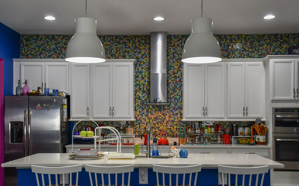 Immagine di una cucina eclettica con pavimento grigio, lavello sottopiano, ante con riquadro incassato, ante bianche, paraspruzzi multicolore, elettrodomestici in acciaio inossidabile e top bianco
