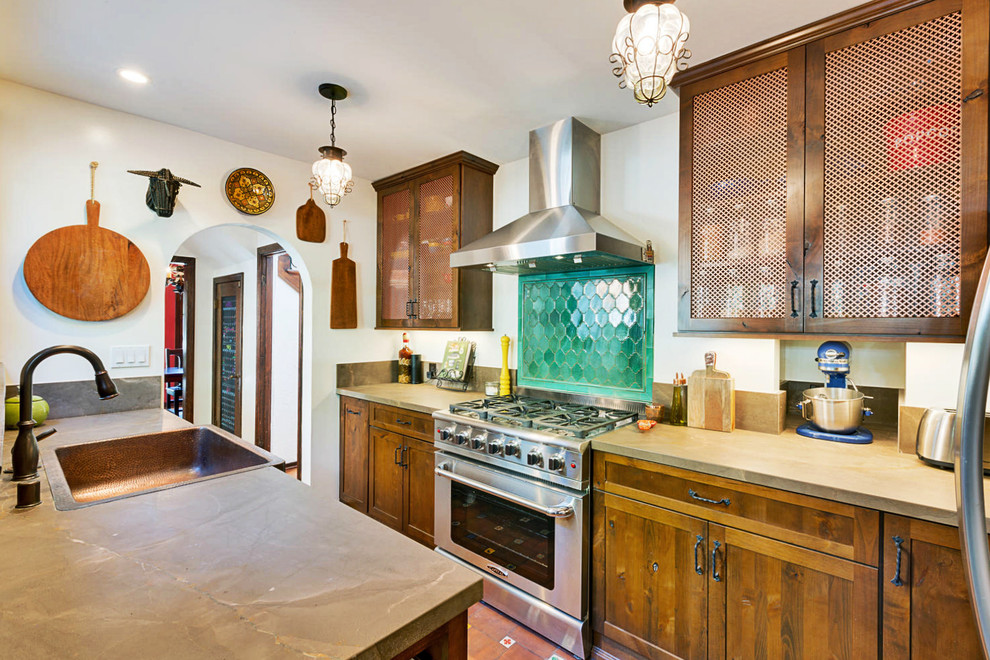 Example of a mid-sized mountain style galley terra-cotta tile and red floor kitchen pantry design in Los Angeles with a farmhouse sink, recessed-panel cabinets, brown cabinets, quartzite countertops, green backsplash, ceramic backsplash, stainless steel appliances and no island