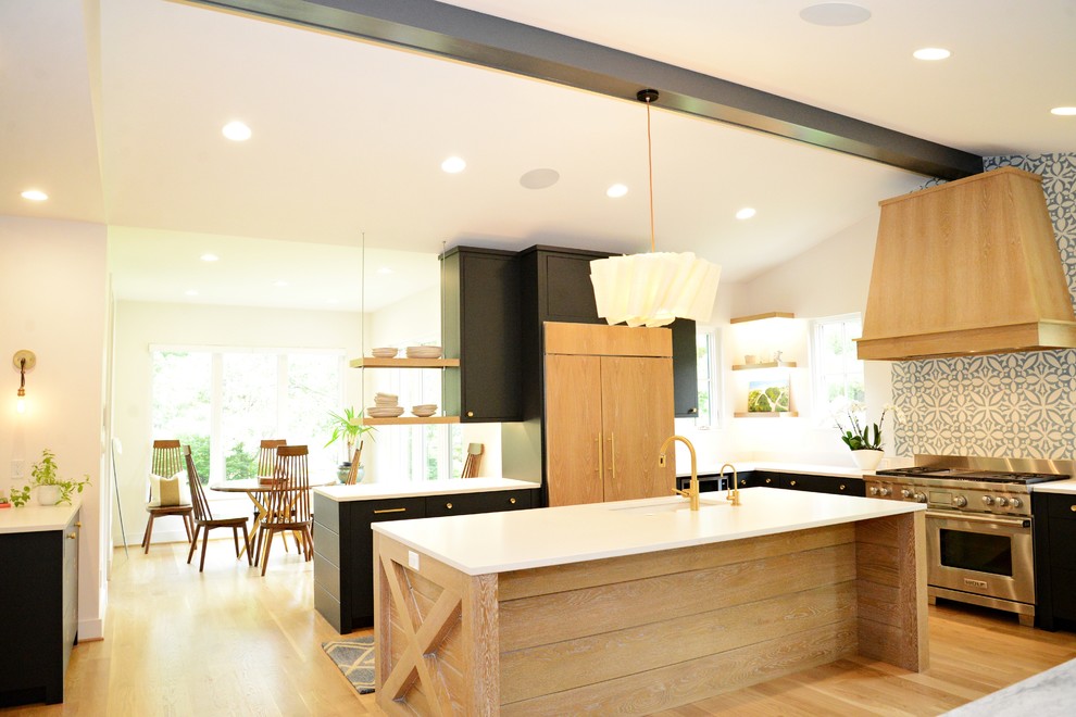 Exempel på ett lantligt kök, med en undermonterad diskho, släta luckor, svarta skåp, bänkskiva i koppar, blått stänkskydd, stänkskydd i cementkakel, rostfria vitvaror, ljust trägolv och en köksö
