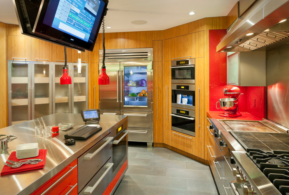 На фото: кухня в стиле модернизм с техникой из нержавеющей стали и телевизором с
