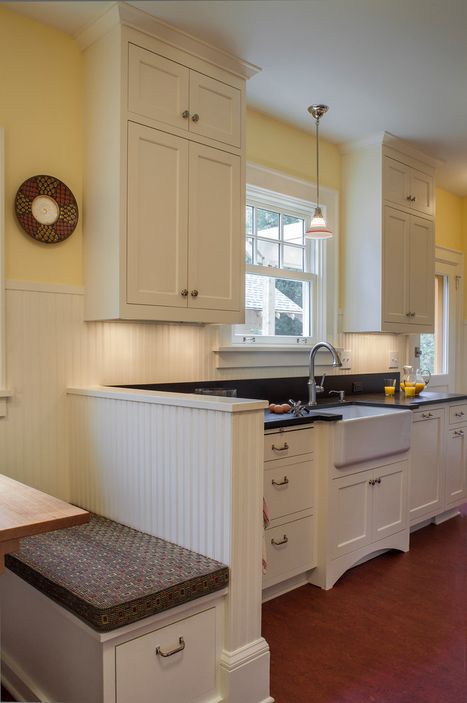 Example of a small arts and crafts single-wall linoleum floor eat-in kitchen design in Portland with a farmhouse sink, shaker cabinets, white cabinets, stainless steel appliances, no island, granite countertops, black backsplash and stone slab backsplash
