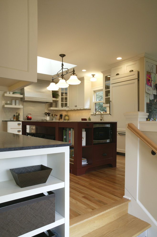 Eat-in kitchen - mid-sized traditional l-shaped light wood floor eat-in kitchen idea in Portland with an undermount sink, shaker cabinets, white cabinets, granite countertops, white backsplash, subway tile backsplash, paneled appliances and an island