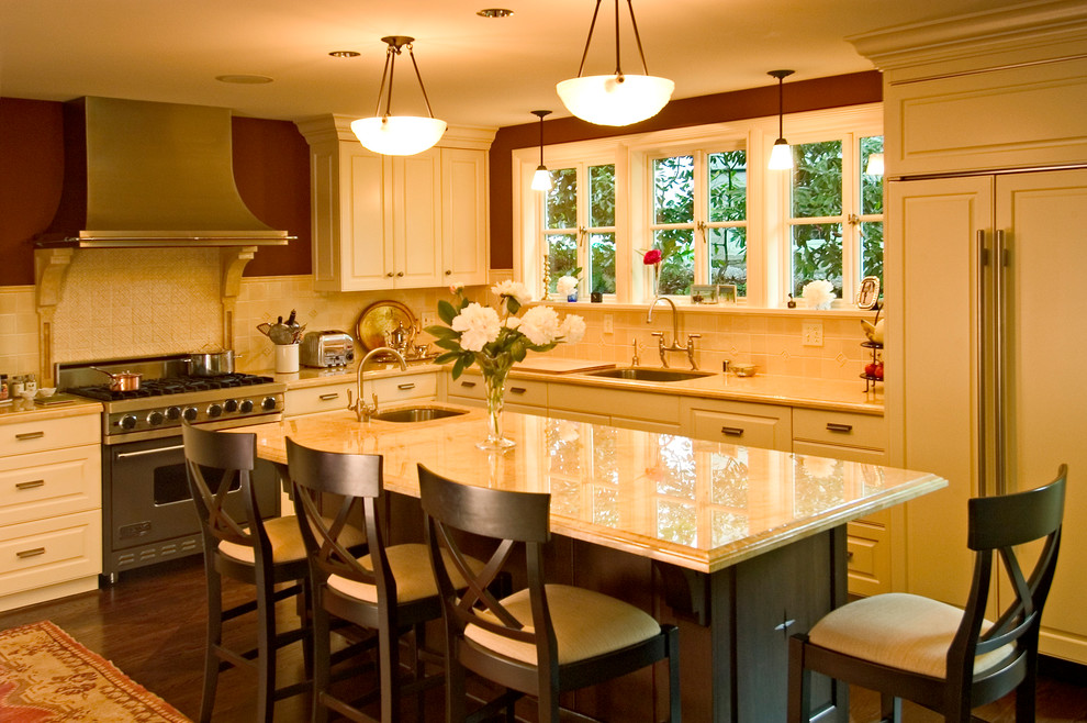 Example of a classic dark wood floor kitchen design in Seattle with an undermount sink, raised-panel cabinets, marble countertops, ceramic backsplash and paneled appliances