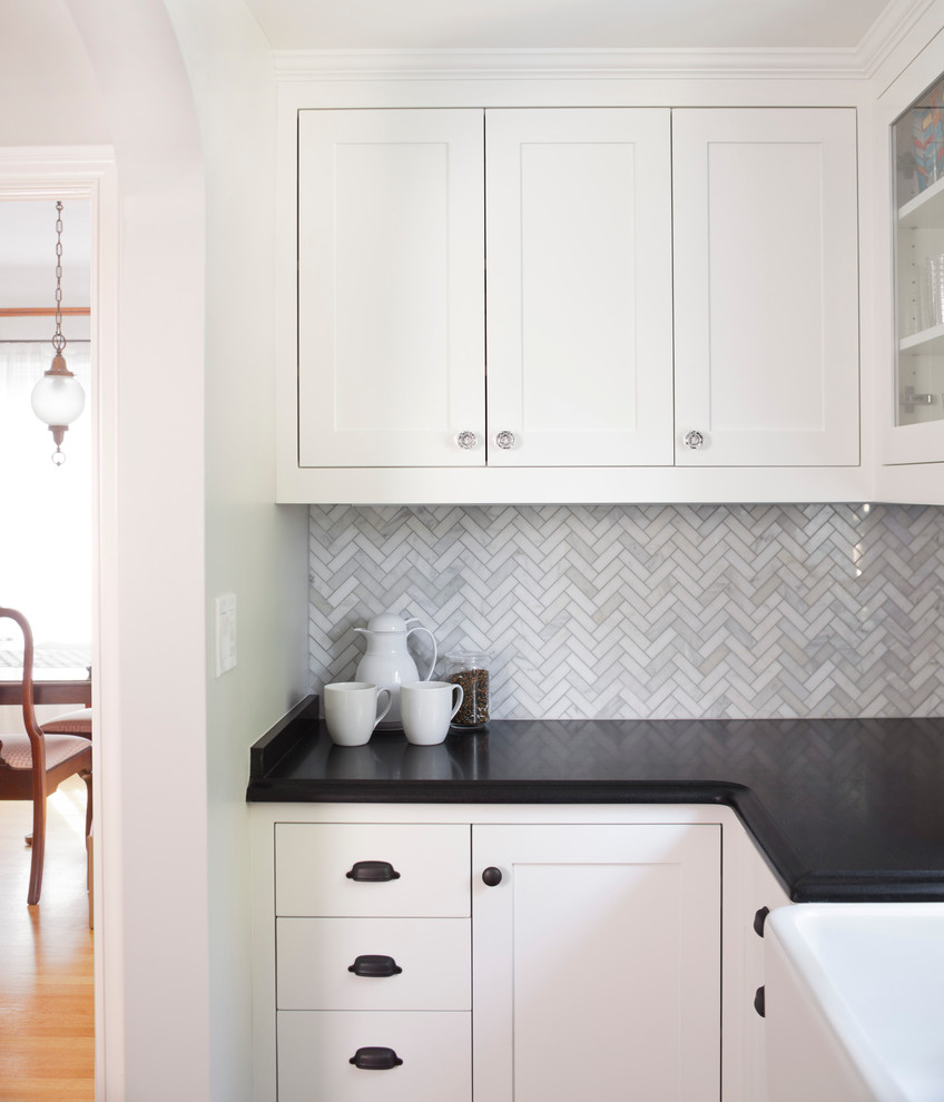 Exempel på ett stort klassiskt kök, med en rustik diskho, luckor med infälld panel, vita skåp, granitbänkskiva, grått stänkskydd, stänkskydd i glaskakel, rostfria vitvaror och ljust trägolv
