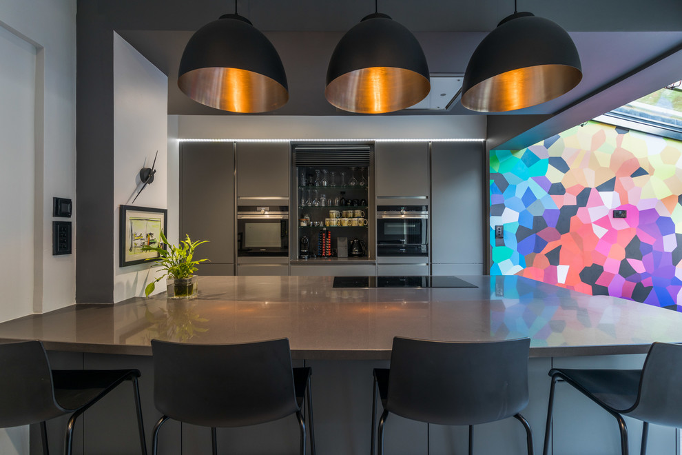 Inspiration for a medium sized modern kitchen/diner in London with flat-panel cabinets, grey cabinets, quartz worktops, a breakfast bar and grey worktops.