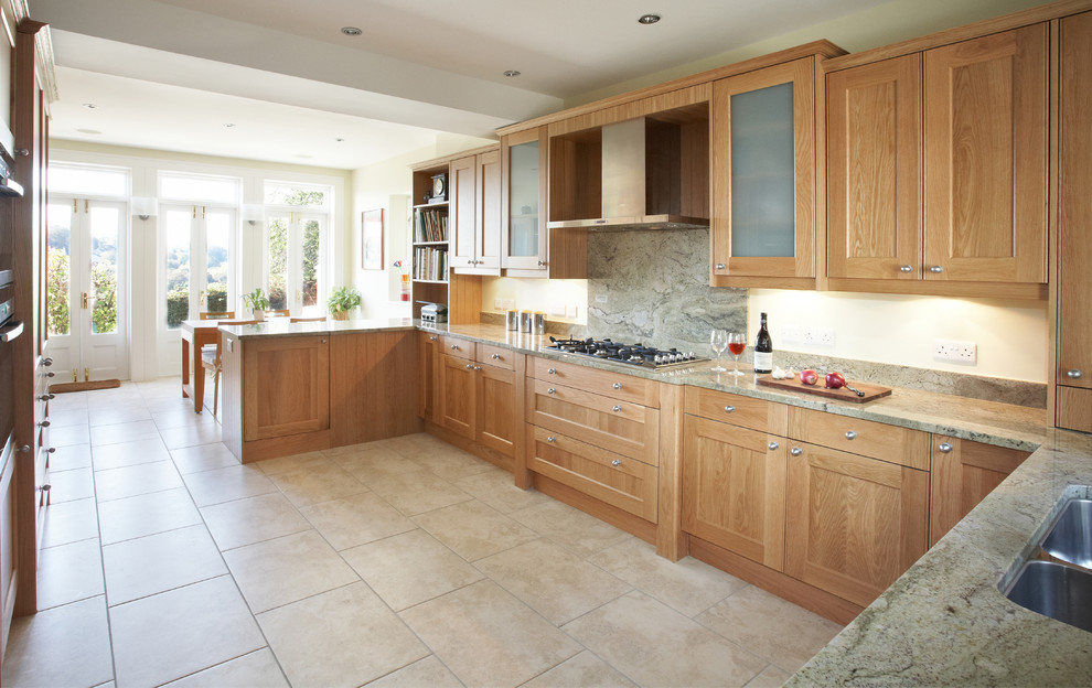 Cette image montre une cuisine minimaliste en bois brun avec un placard à porte shaker, un plan de travail en granite et un sol en travertin.