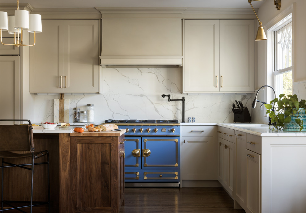ニューヨークにある高級な広いトランジショナルスタイルのおしゃれなキッチン (ドロップインシンク、白いキャビネット、クオーツストーンカウンター、白いキッチンパネル、大理石のキッチンパネル、パネルと同色の調理設備、無垢フローリング、茶色い床、白いキッチンカウンター、落し込みパネル扉のキャビネット) の写真