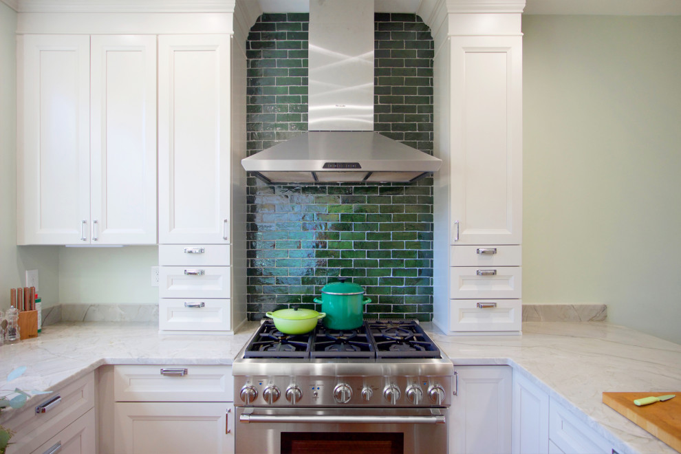 Klassisk inredning av ett avskilt, litet grå grått u-kök, med luckor med infälld panel, vita skåp, bänkskiva i kvartsit, grönt stänkskydd, stänkskydd i terrakottakakel, rostfria vitvaror och en halv köksö
