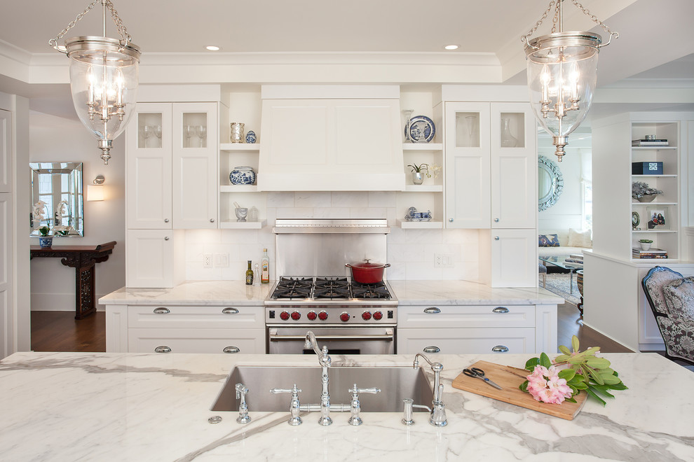 Inredning av ett modernt mellanstort l-kök, med en undermonterad diskho, skåp i shakerstil, vita skåp, marmorbänkskiva, vitt stänkskydd, stänkskydd i stenkakel, rostfria vitvaror, mellanmörkt trägolv och en köksö