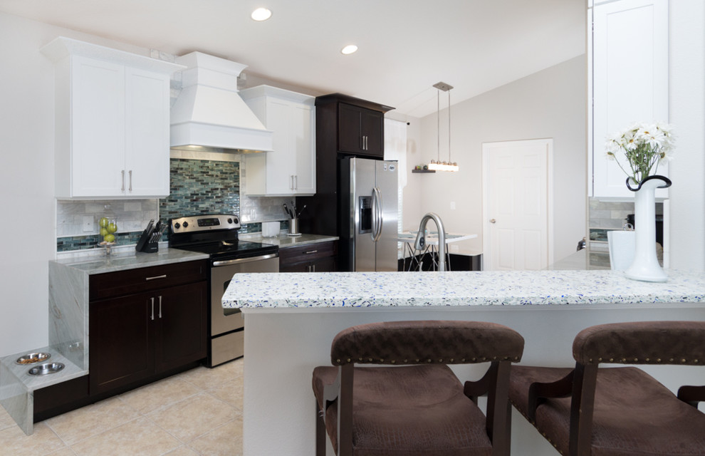 Eat-in kitchen - small transitional galley ceramic tile and black floor eat-in kitchen idea in Orlando with shaker cabinets, white cabinets, quartzite countertops, gray backsplash, stone tile backsplash, stainless steel appliances and a peninsula