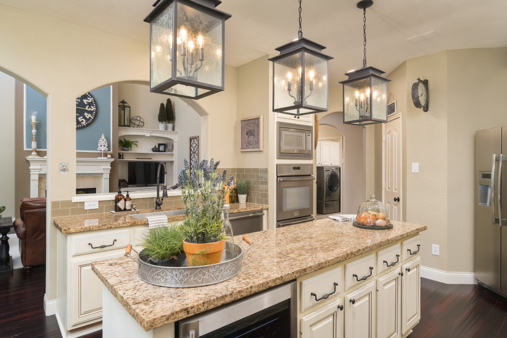 Example of a mid-sized transitional u-shaped brown floor enclosed kitchen design in Houston with an undermount sink, raised-panel cabinets, beige cabinets, gray backsplash, subway tile backsplash, stainless steel appliances, an island and beige countertops