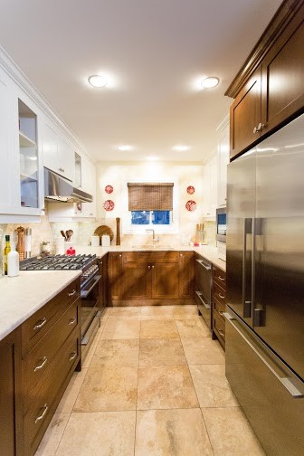 This is an example of a medium sized classic galley kitchen/diner in Toronto with a built-in sink, shaker cabinets, dark wood cabinets, laminate countertops, beige splashback, stone tiled splashback, stainless steel appliances, marble flooring and a breakfast bar.