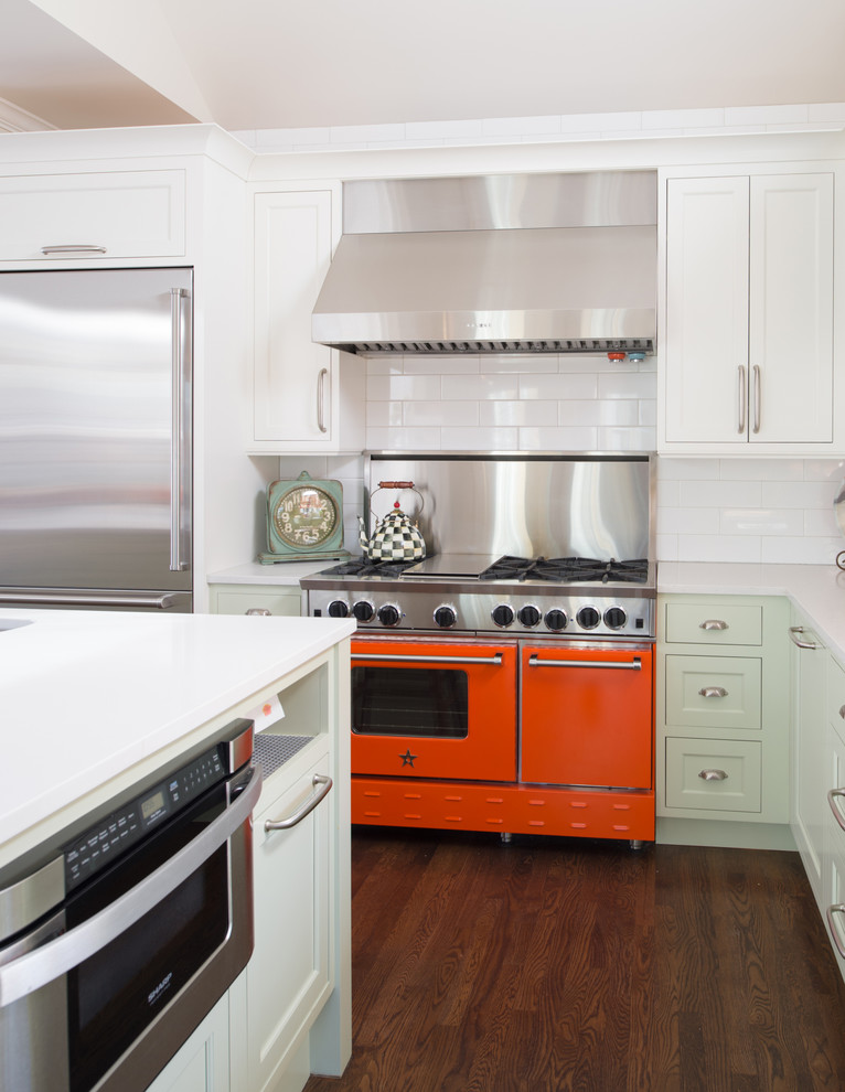 Large transitional l-shaped dark wood floor open concept kitchen photo in Kansas City with a farmhouse sink, recessed-panel cabinets, green cabinets, quartz countertops, white backsplash, ceramic backsplash, stainless steel appliances and an island