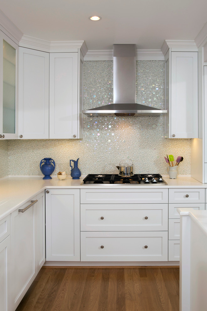 Foto di una cucina design con ante in stile shaker, ante bianche, top in vetro, paraspruzzi bianco, paraspruzzi con piastrelle di vetro, elettrodomestici da incasso e parquet chiaro