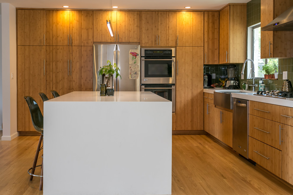 Example of a large cottage single-wall light wood floor kitchen design in Los Angeles with quartz countertops, green backsplash, glass tile backsplash, stainless steel appliances and an island